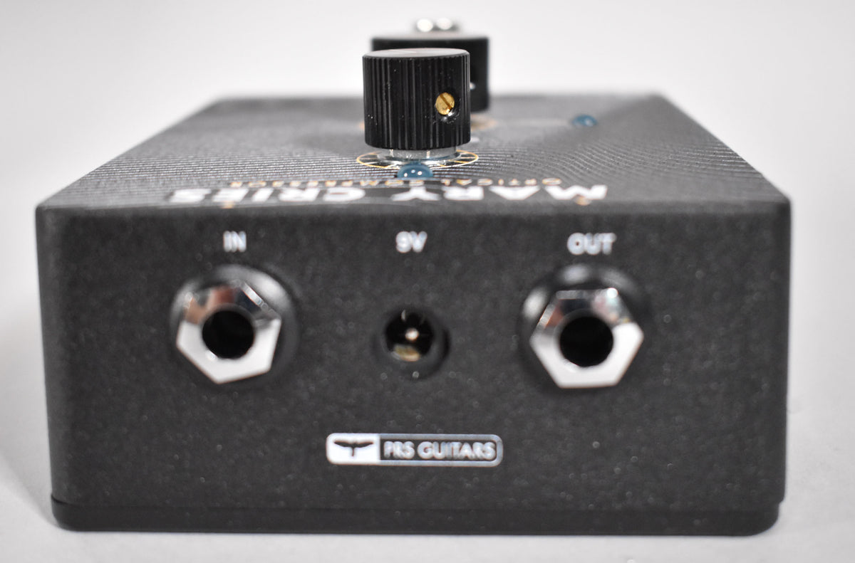 The black textured pedal is viewed from the back, showing the input, 9V power, and output jacks.
