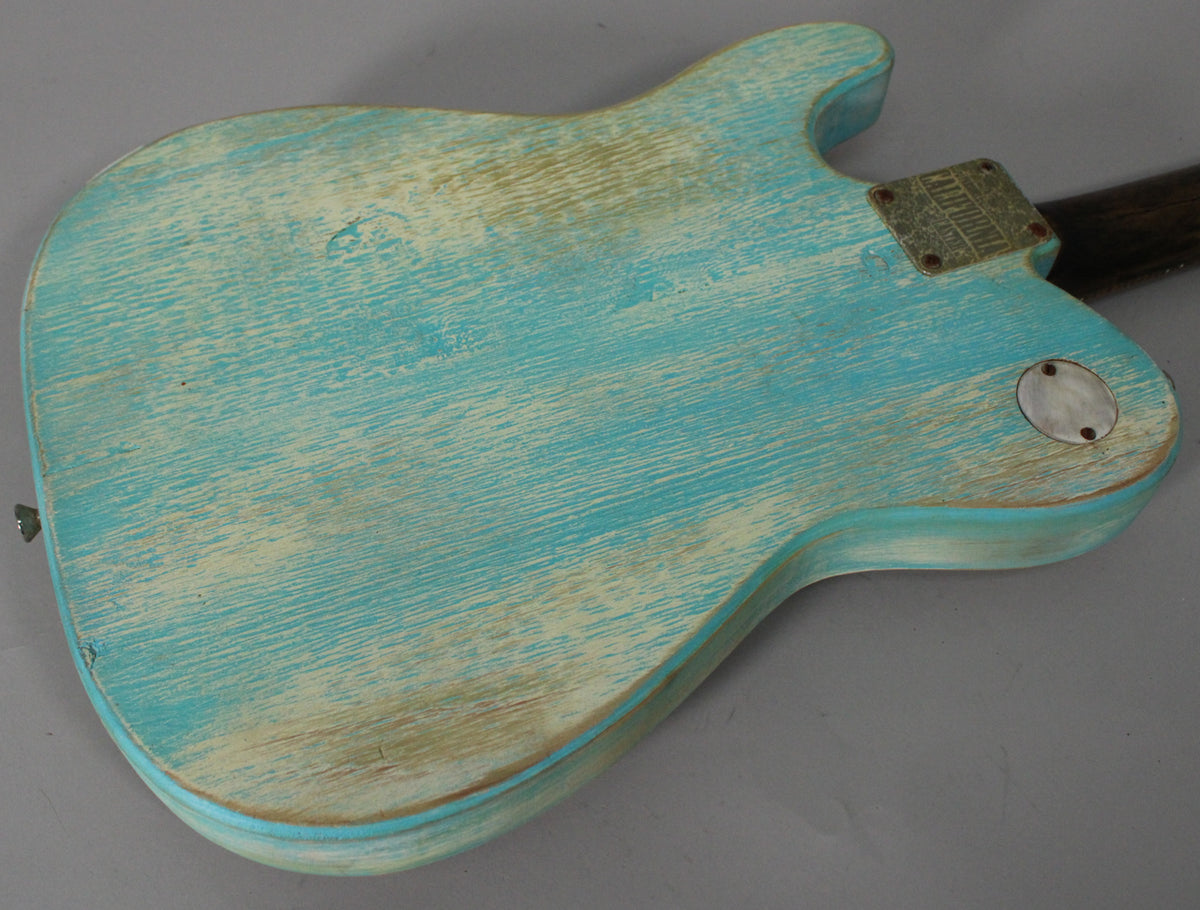 The back of the guitar shows a heavily relic'd blue finish with significant wood grain showing through, a metal neck plate, and a round control plate.