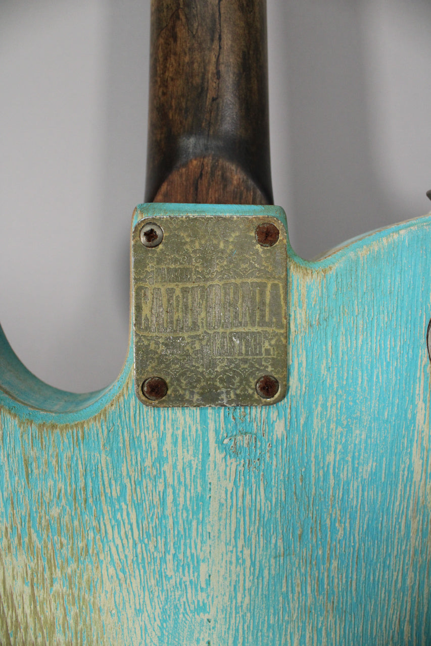 Close-up of the guitar's back, showing the heavily relic'd blue finish with exposed wood grain and a tarnished neck plate.