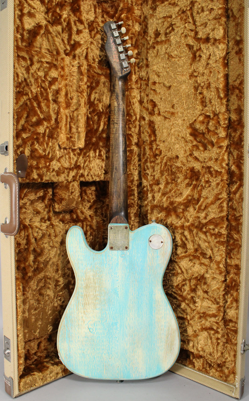 The guitar's back is visible, showing a heavily relic'd light blue finish over white, a worn dark neck, and a tweed case.