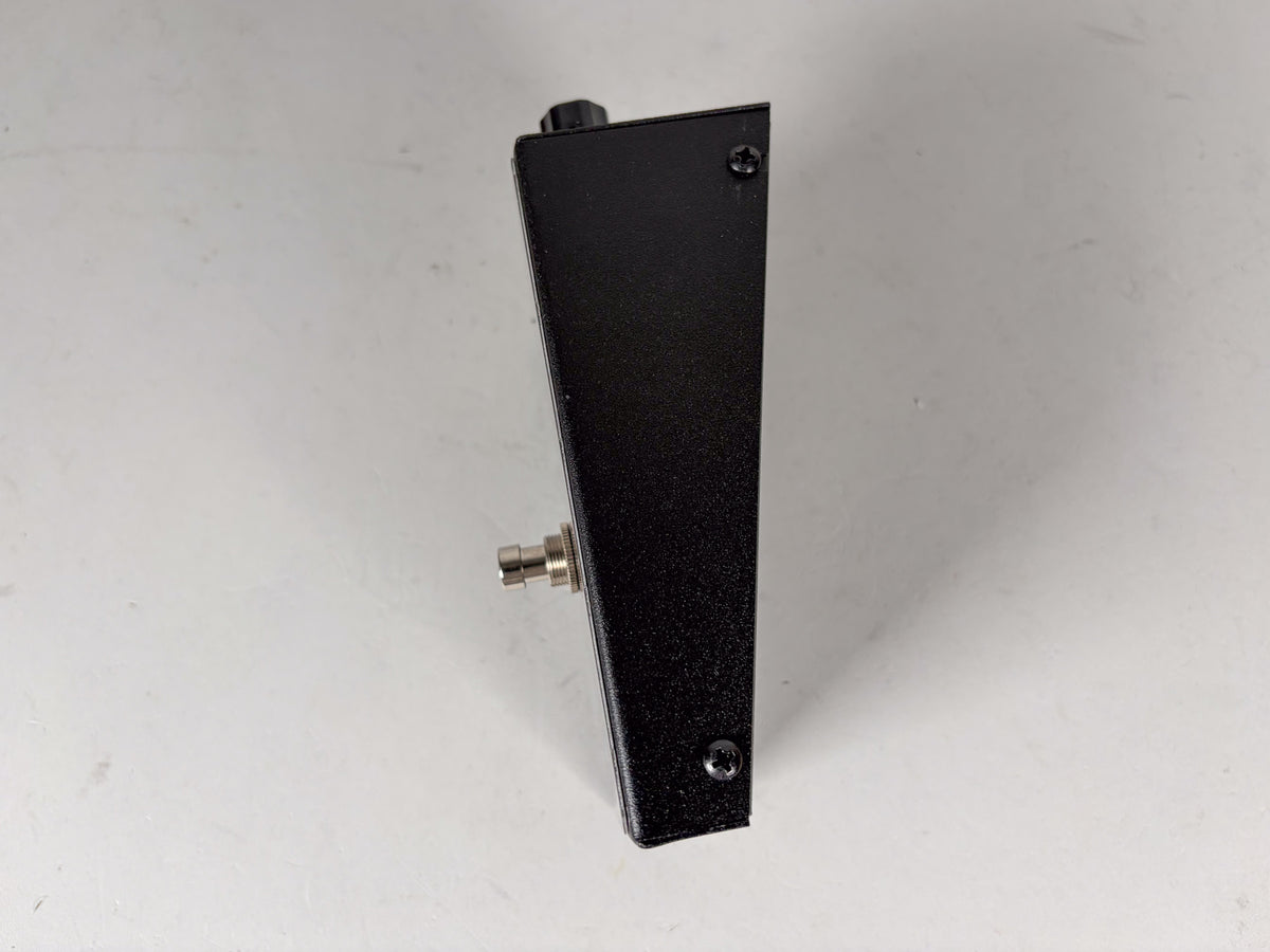 The black textured pedal is viewed from the right side, showing a silver input jack and a single black knob on top.