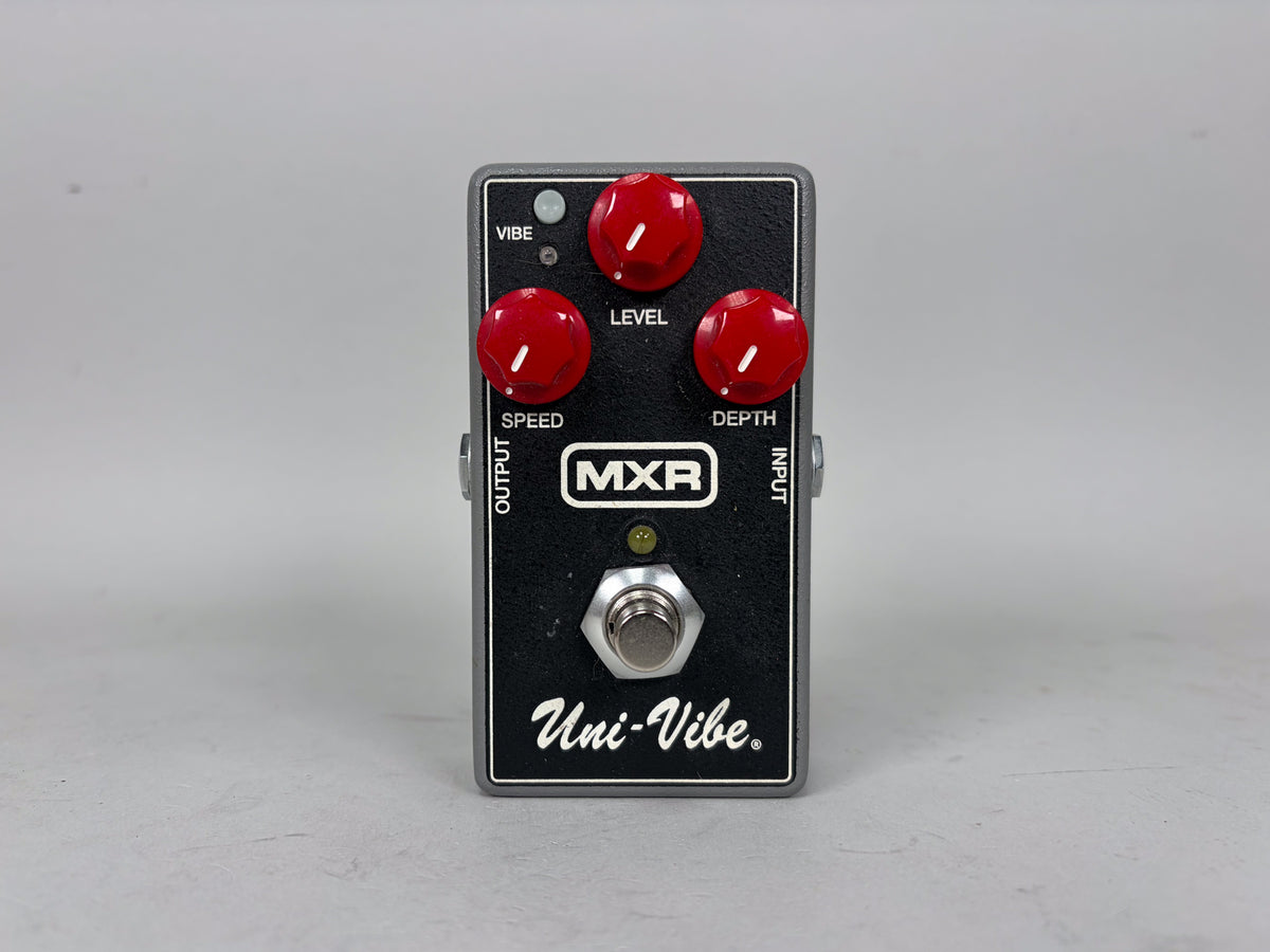 Front view of a dark gray pedal with a black faceplate, three red control knobs, and a silver footswitch.
