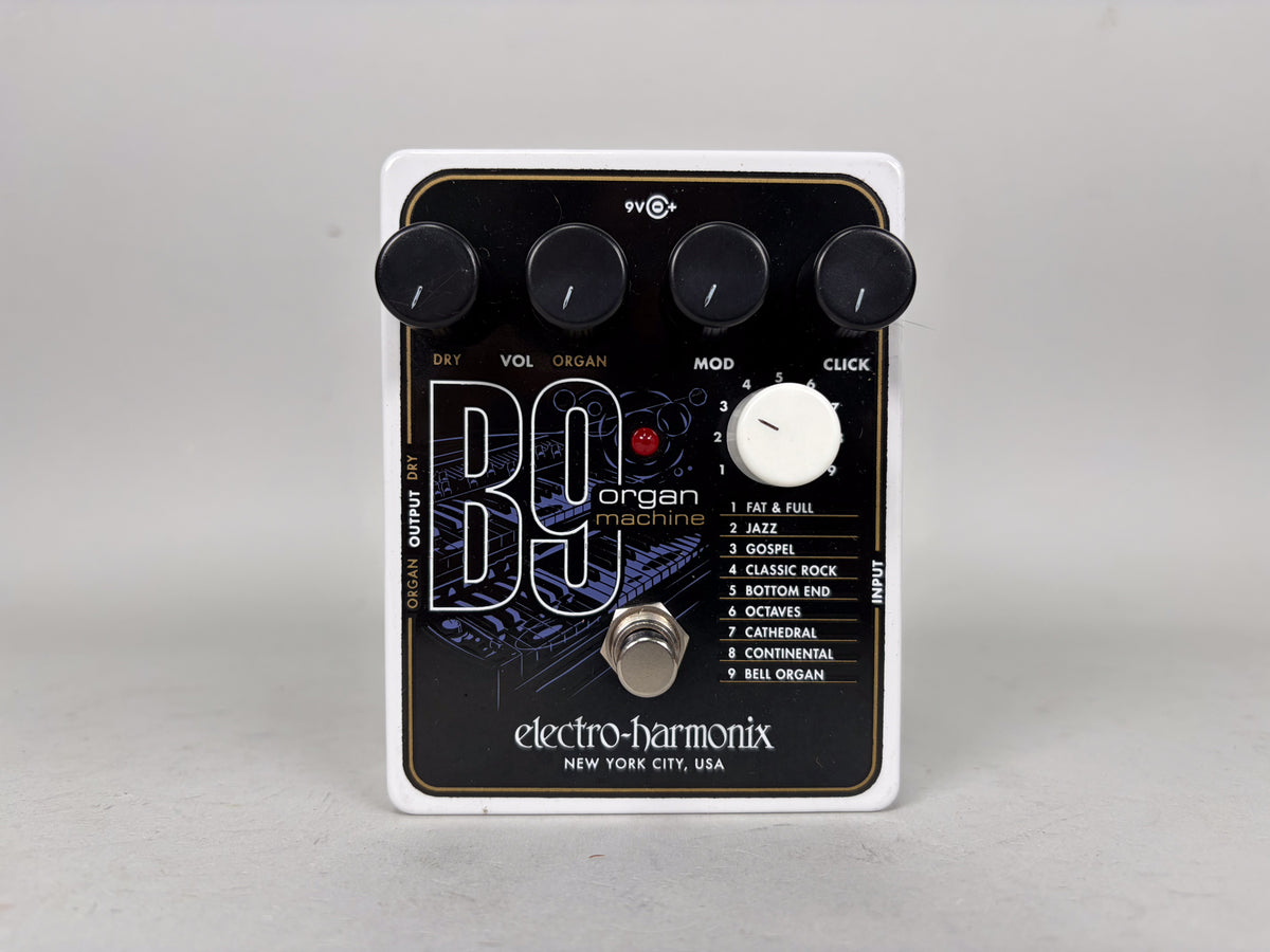 A white guitar pedal with a black faceplate, four black knobs, a large white selector knob, and a silver footswitch.