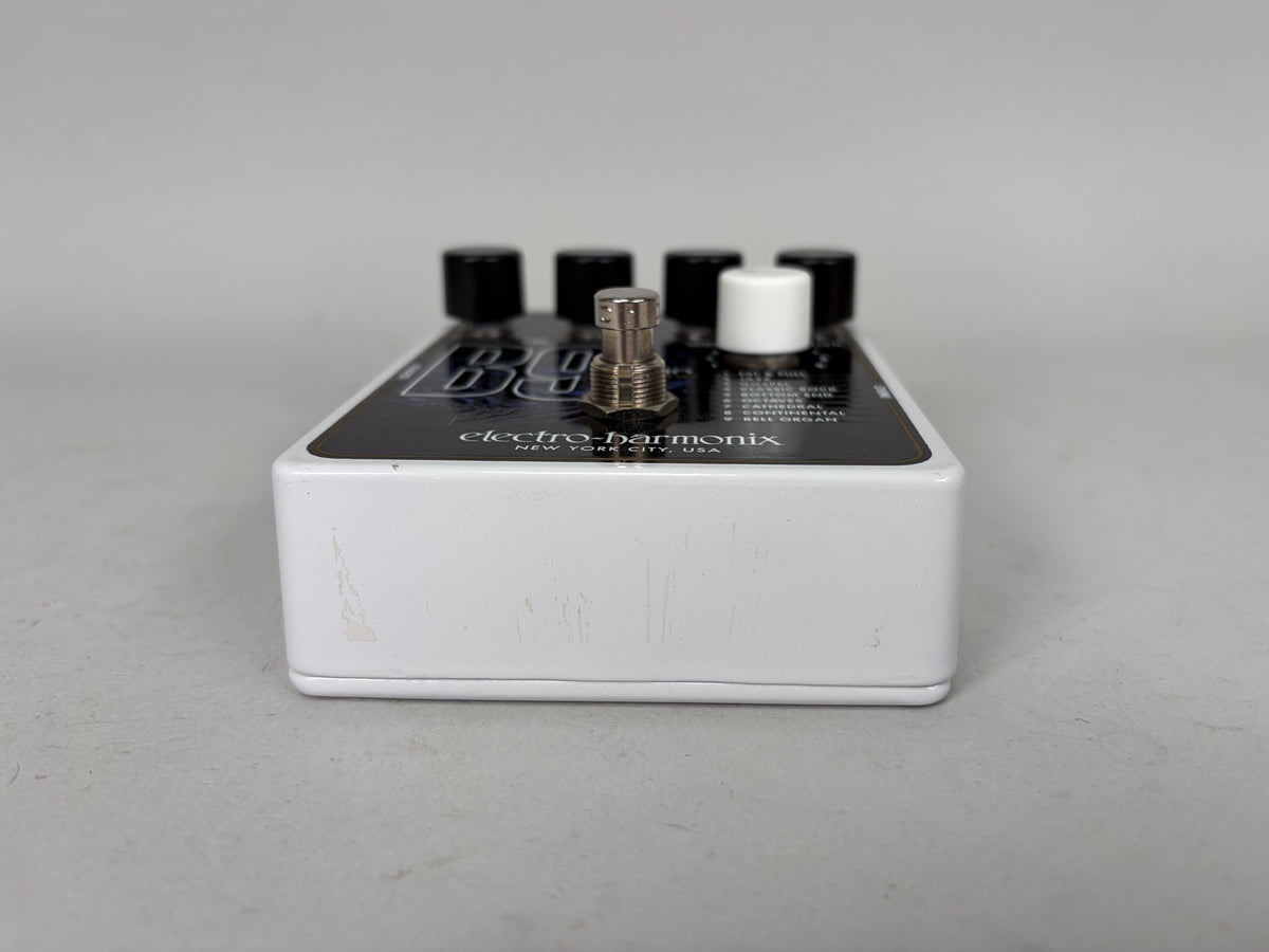 White guitar pedal, viewed from the right side, showing black control knobs, a silver footswitch, and light scuffs on the side.