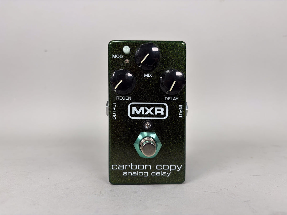 A dark green metallic effect pedal, viewed from above, with four black control knobs and a teal footswitch.