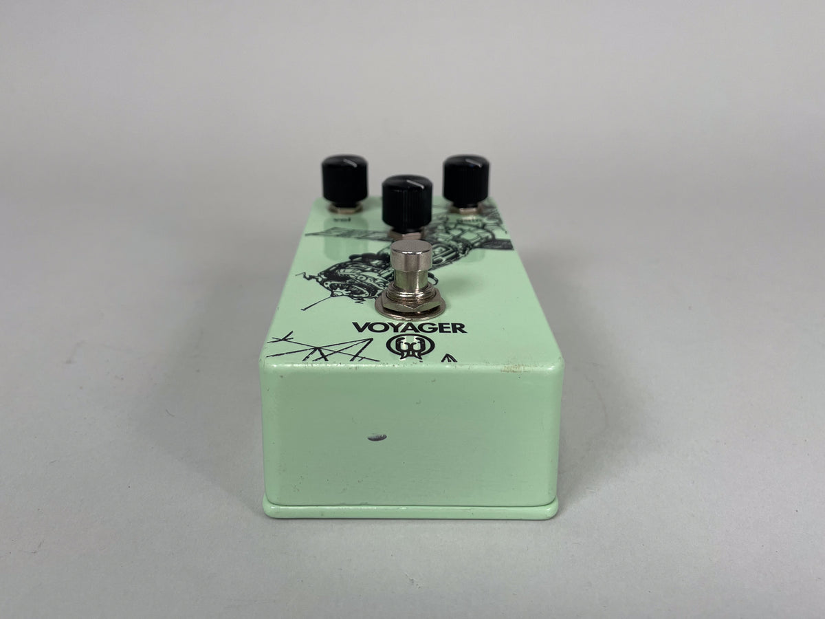 The light green pedal is angled from the front right, showing the foot switch, three black knobs, and a black graphic.