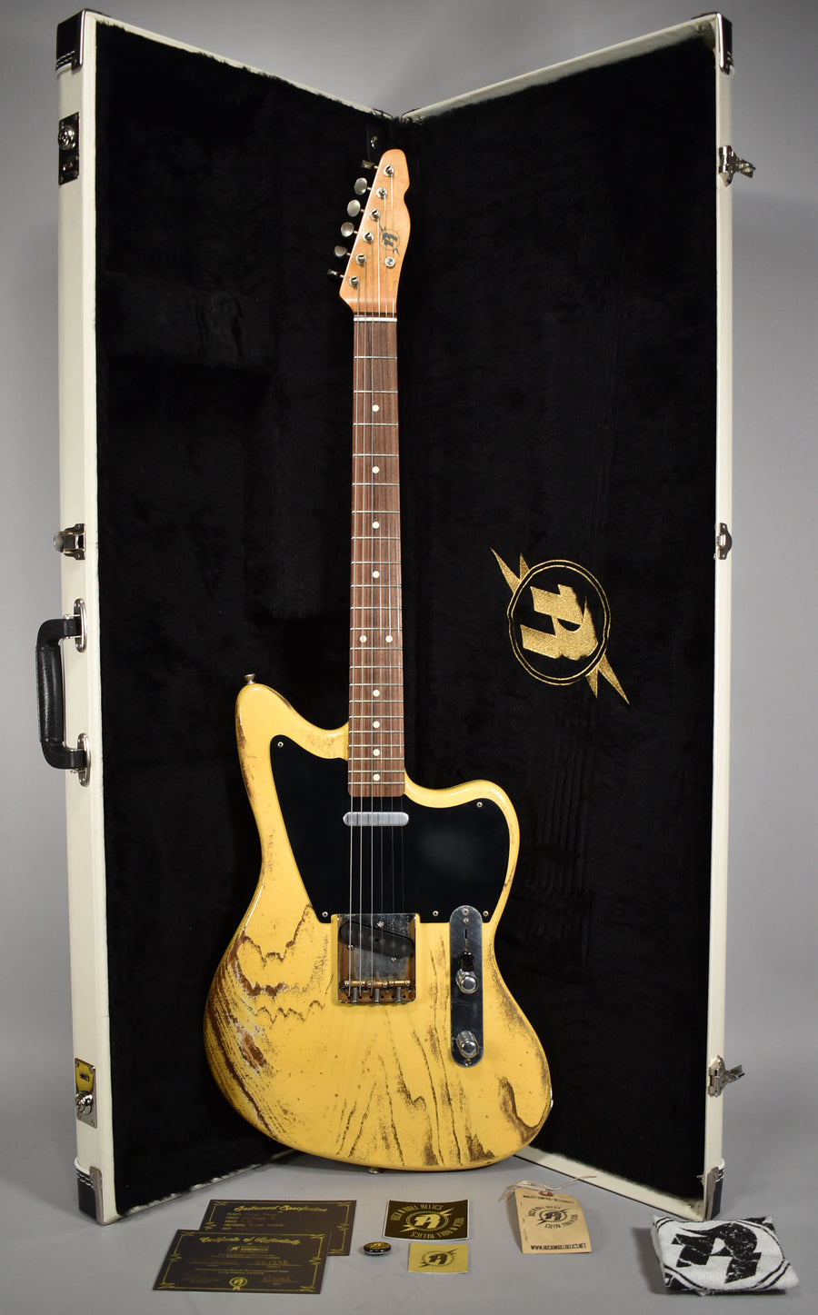 Full-length view of a heavily relic'd butterscotch blonde guitar with a black pickguard, single-coil pickups, and a maple neck, in its open white hard case.