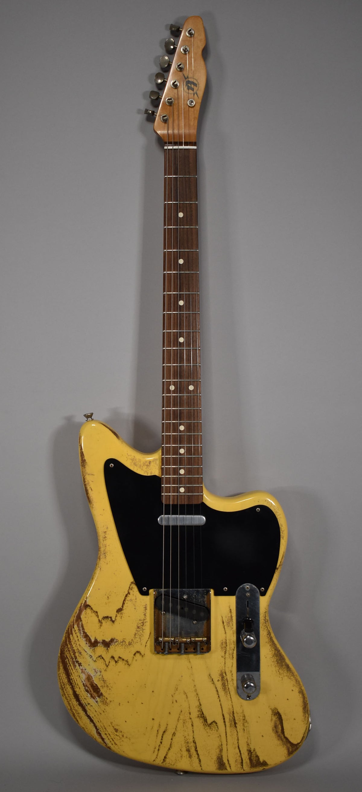 Full front view of a distressed butterscotch blonde electric guitar with a black pickguard and dark wood fretboard.