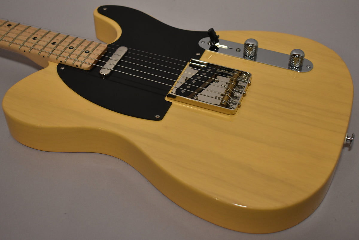 The butterscotch T-style electric guitar body, with a black pickguard and chrome hardware, is angled to show the bridge and controls.