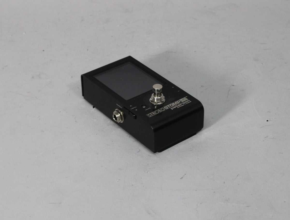 Black tuner pedal with a large screen, a chrome footswitch, and an input jack visible on the left side.