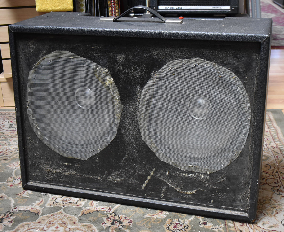 A black combo amp with two large speakers covered by metal mesh, showing significant wear, dust, and peeling on the front panel.