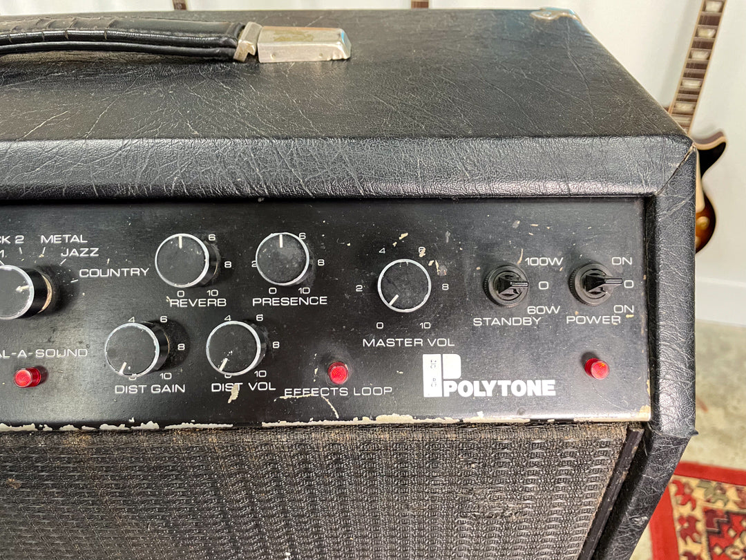 Close-up of the amp's textured black control panel, showing numerous knobs, two red indicator lights, and two toggle switches.