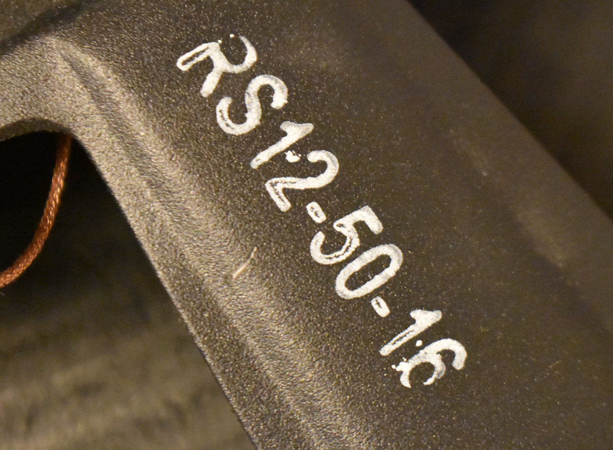 Close-up of the speaker's dark gray, textured frame, showing a copper wire and white stenciled numbers.