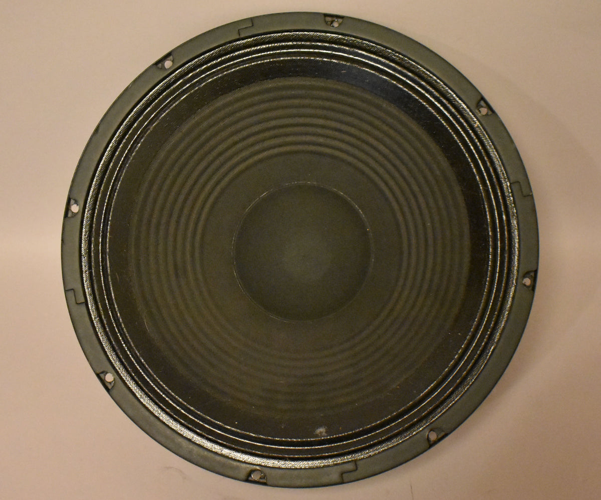 Full view of the dark green speaker cone with concentric rings, surrounded by a black frame with eight mounting holes.