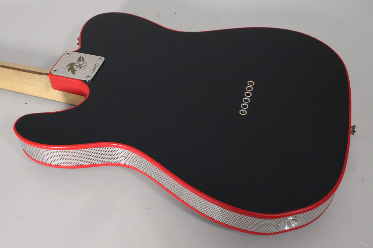 The guitar's matte black back and red sides are visible, with a perforated metal strip wrapping the lower body edge.