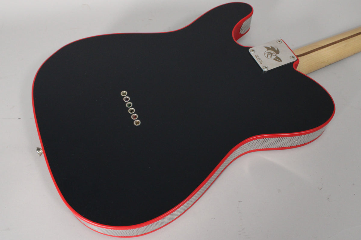 The guitar's matte black back with red binding and silver mesh trim is angled, showing six string ferrules and a neck plate.