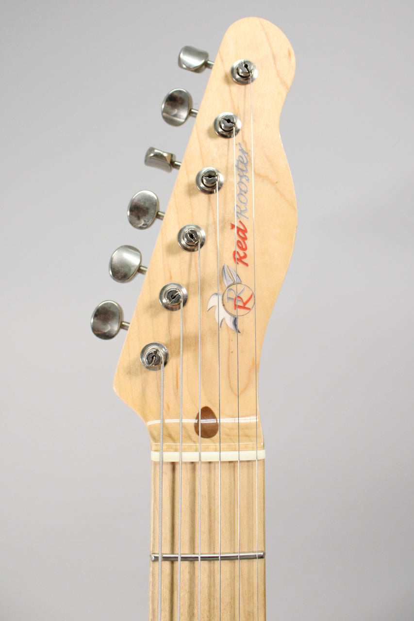 Close-up of the natural finish headstock and maple fretboard, showing six chrome tuners and a white nut.