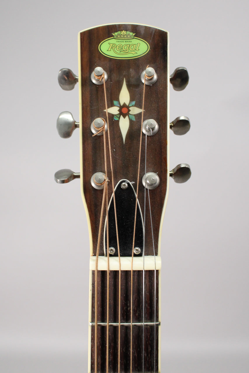 The dark wood headstock, with a green oval logo and mother-of-pearl floral inlay, is topped with six chrome tuners.