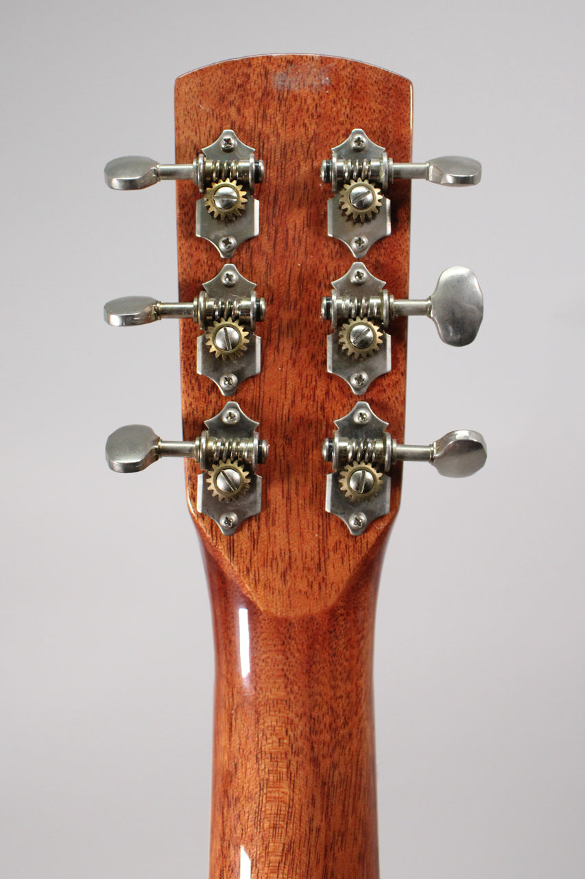 Rear view of the headstock and upper neck, showing six open-gear tuners with brushed metal buttons and brass gears.