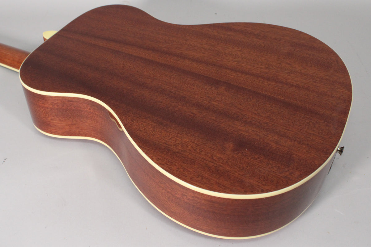 The back and side of a mahogany-stained acoustic guitar with cream binding, showing a visible output jack on the lower bout.