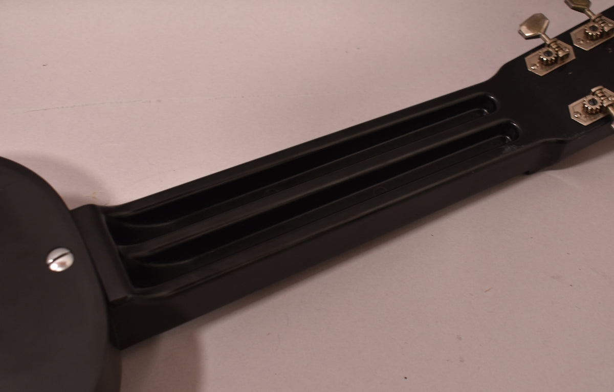 The black Bakelite lap steel's neck and headstock are visible, showing three parallel grooves running down the neck and four chrome tuners.