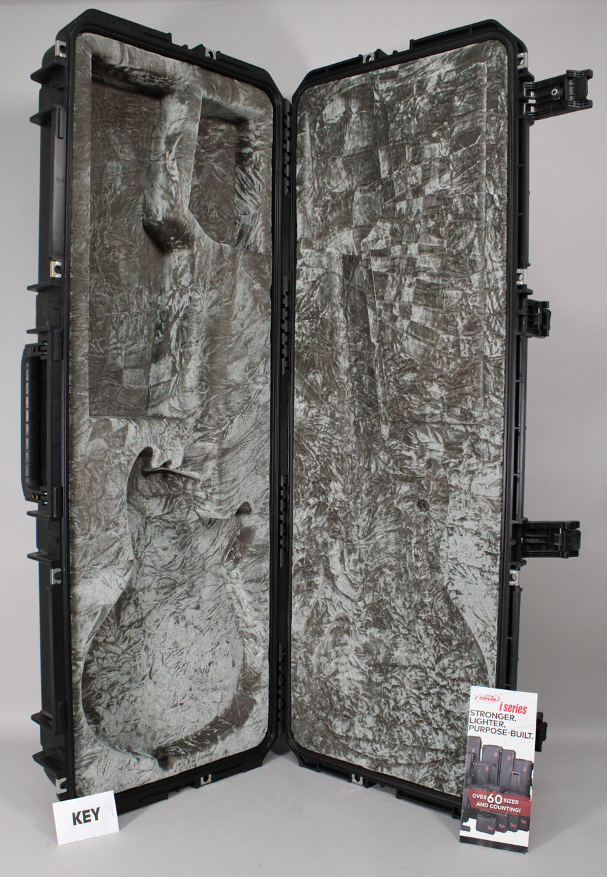 Black hard case, open and angled, revealing a grey crushed velvet interior molded for a guitar, with a handle on the left.