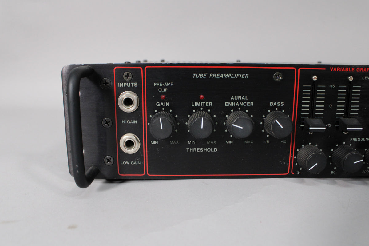 Close-up of the black rackmount amp's front panel, showing two input jacks, four rotary knobs, and a bank of vertical sliders.