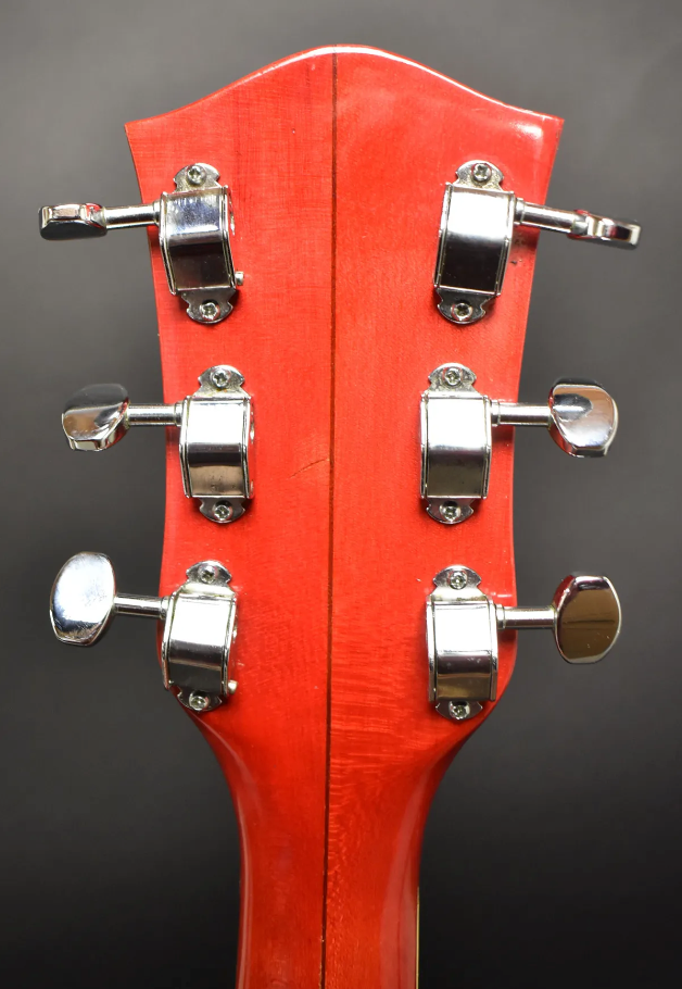 Rear view of the cherry red headstock and upper neck, showing six chrome tuners with oval buttons and a vertical seam.