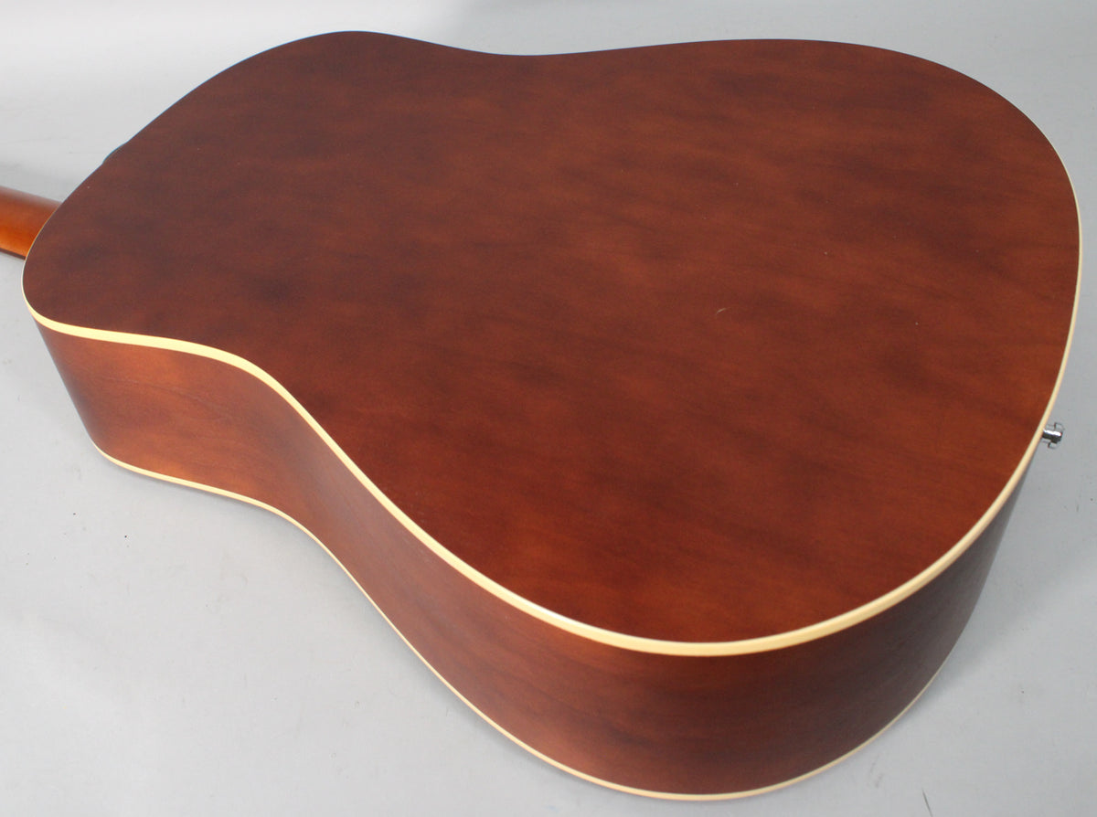 The back of a reddish-brown acoustic guitar with a matte finish and light binding, viewed from the upper left, showing a strap button.