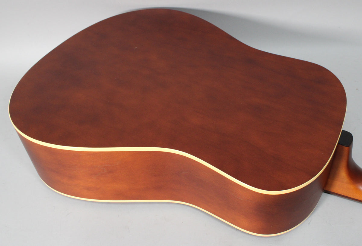 The acoustic guitar's dark brown back and side are visible from above, showing light binding and a matte finish.