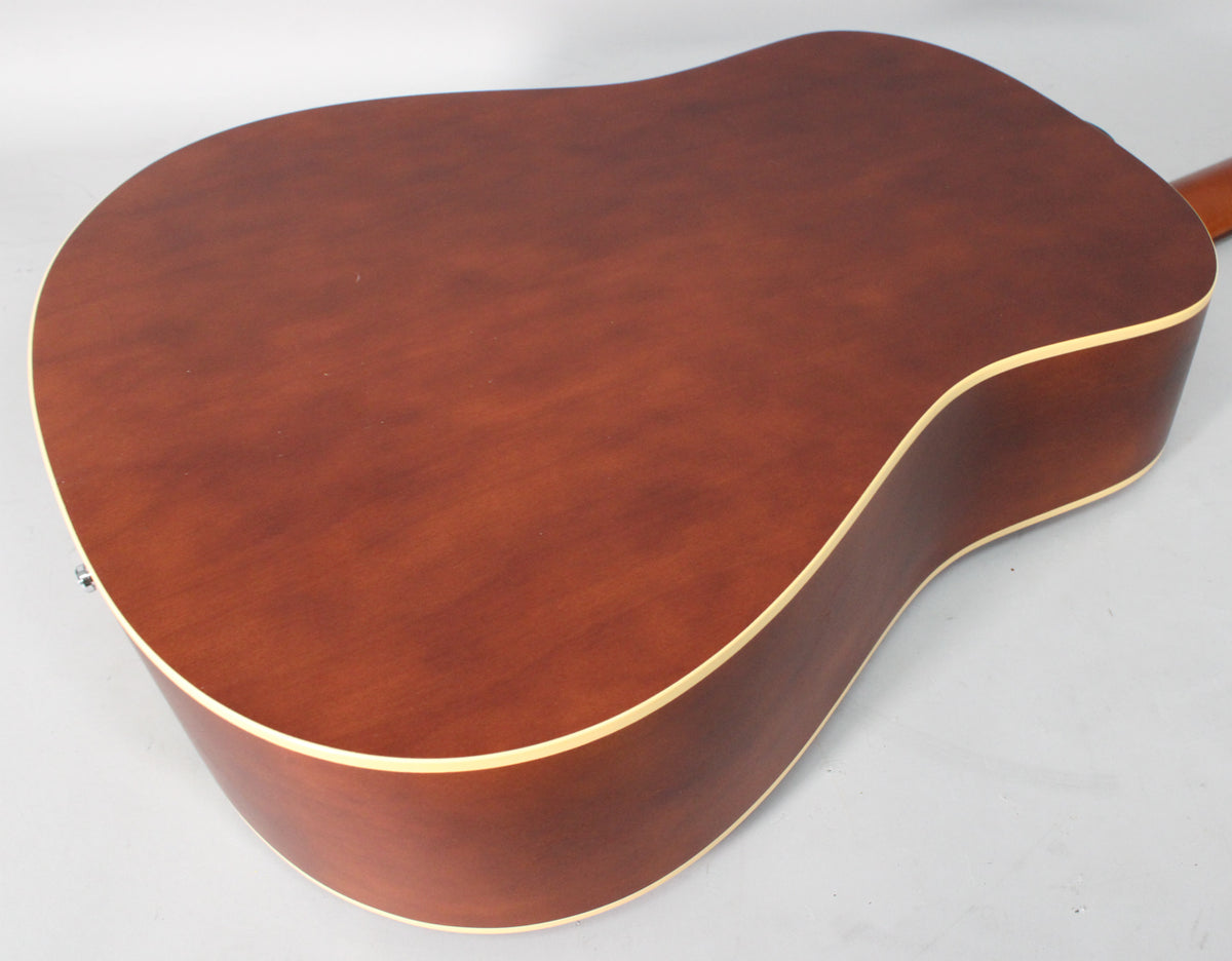 The acoustic guitar's dark brown back and sides, with light binding, are angled from the lower bout towards the neck.
