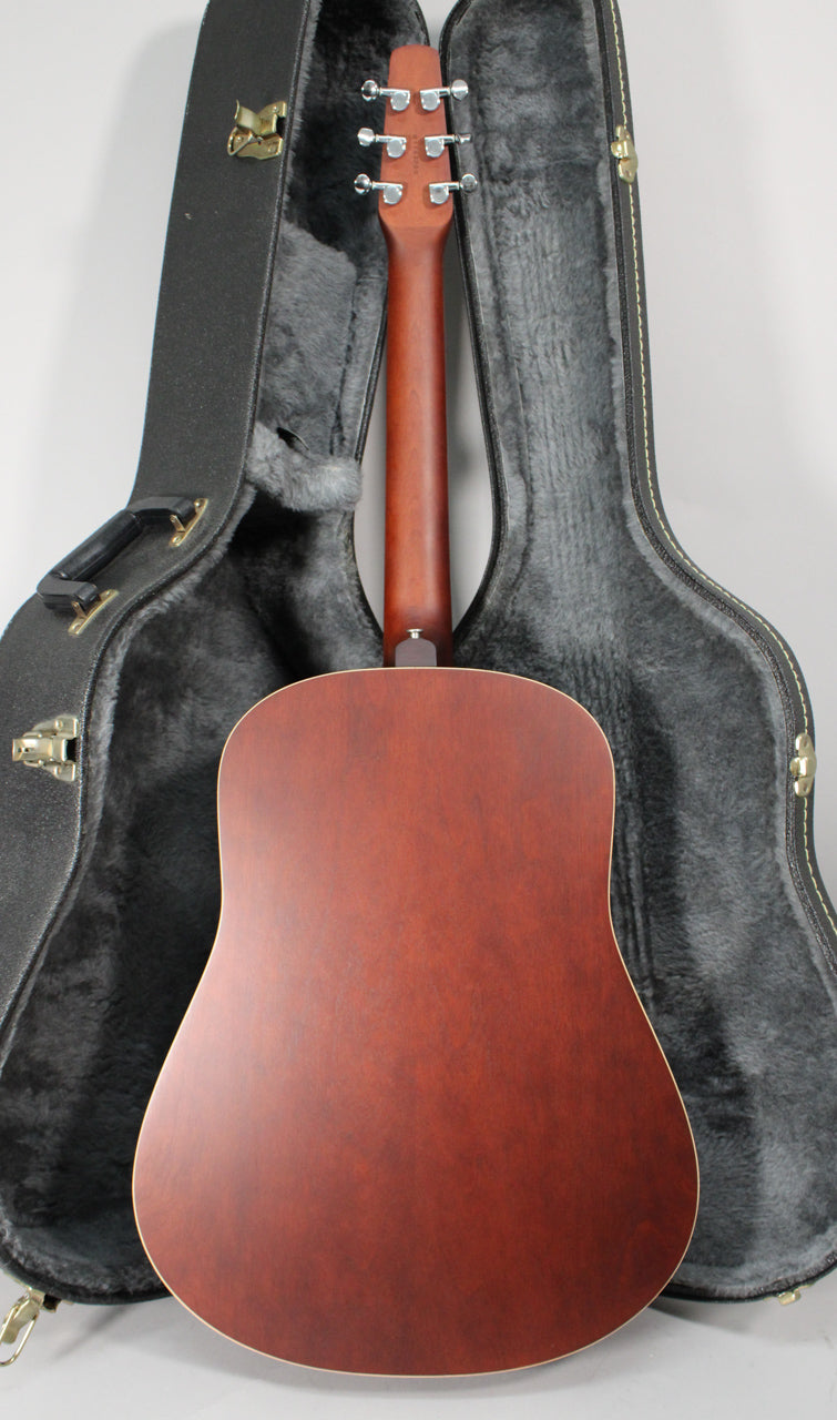 The back of the acoustic guitar, with a reddish-brown matte finish, is framed between the open, dark gray hard shell case.
