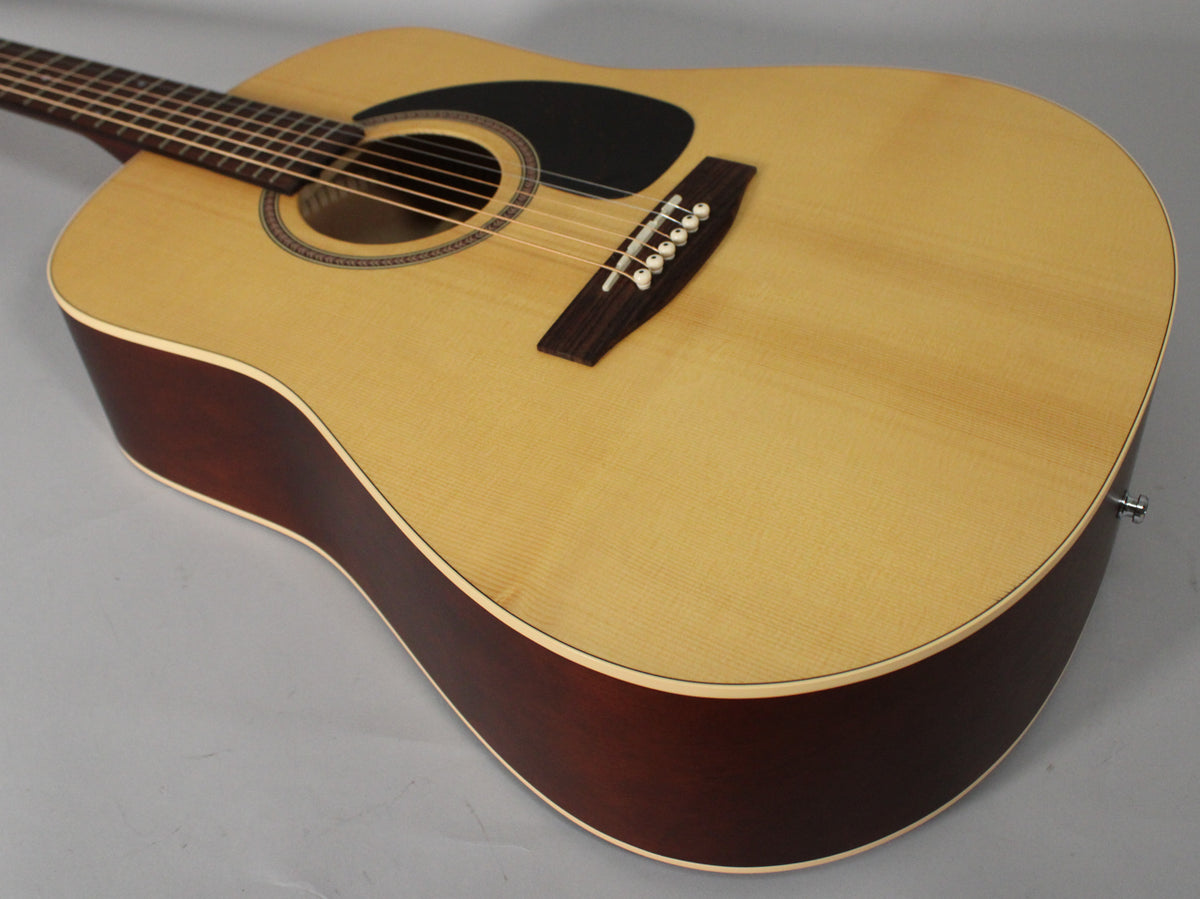 Acoustic guitar body, light spruce top with dark cherry sides, black pickguard, and dark wood bridge with white pins.