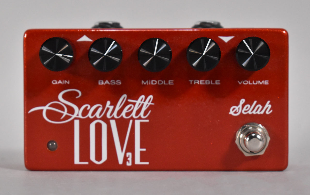 A top-down view of a metallic red pedal with five black control knobs, a small LED, and a chrome footswitch.