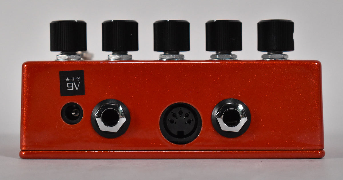 The rear of the glittery orange pedal shows five black control knobs, a 9V power input, two 1/4" jacks, and a 5-pin MIDI port.