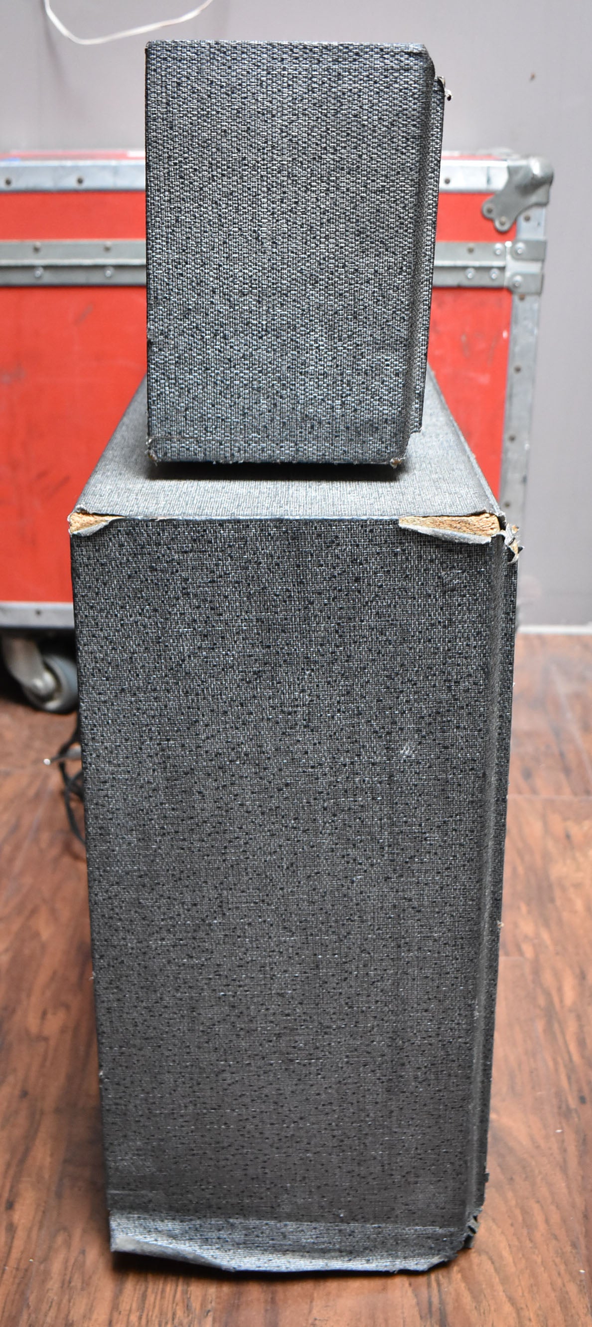 The gray tweed amp head sits atop its matching cabinet, both showing wear and tear on their corners.