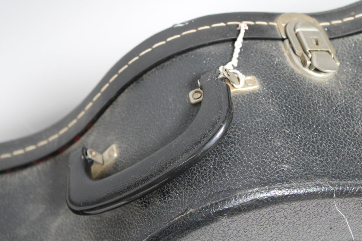 Close-up of the black textured case handle and a silver latch, with visible dust and wear on the black exterior.