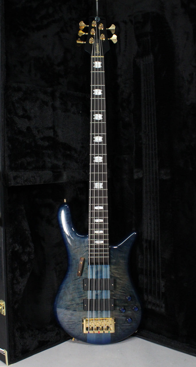 Full-length view of a blue fade gloss bass guitar with gold hardware, black pickups, and mother-of-pearl block inlays.