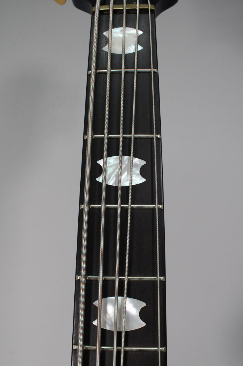 The bass's dark fretboard is shown from above, with five strings and three mother-of-pearl crown inlays visible.