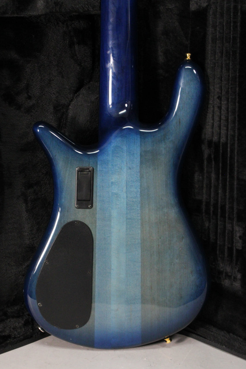The bass guitar's back, in a blue fade gloss finish, shows a black battery compartment and a larger black control cavity cover.