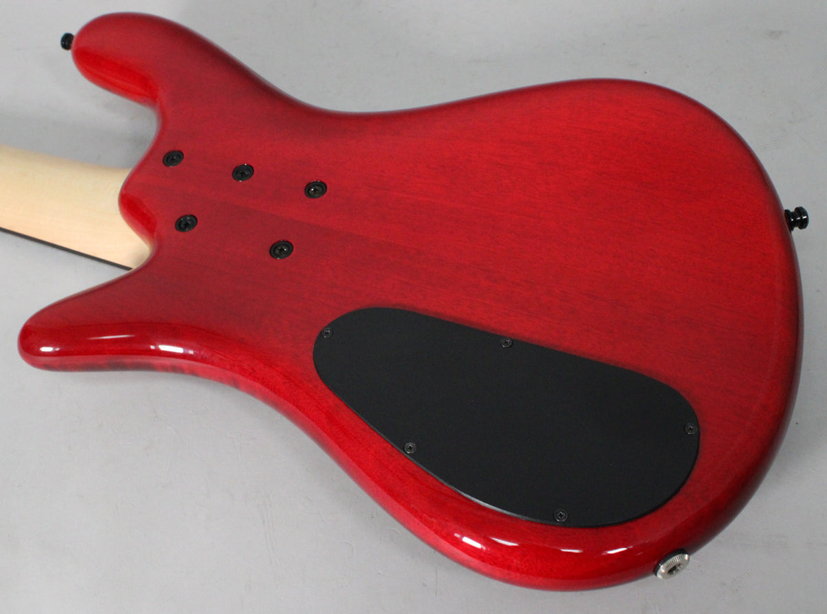 The back of a cherry flame bass, showing the neck joint, 5 black neck bolts, a black control cavity cover, and output jack.