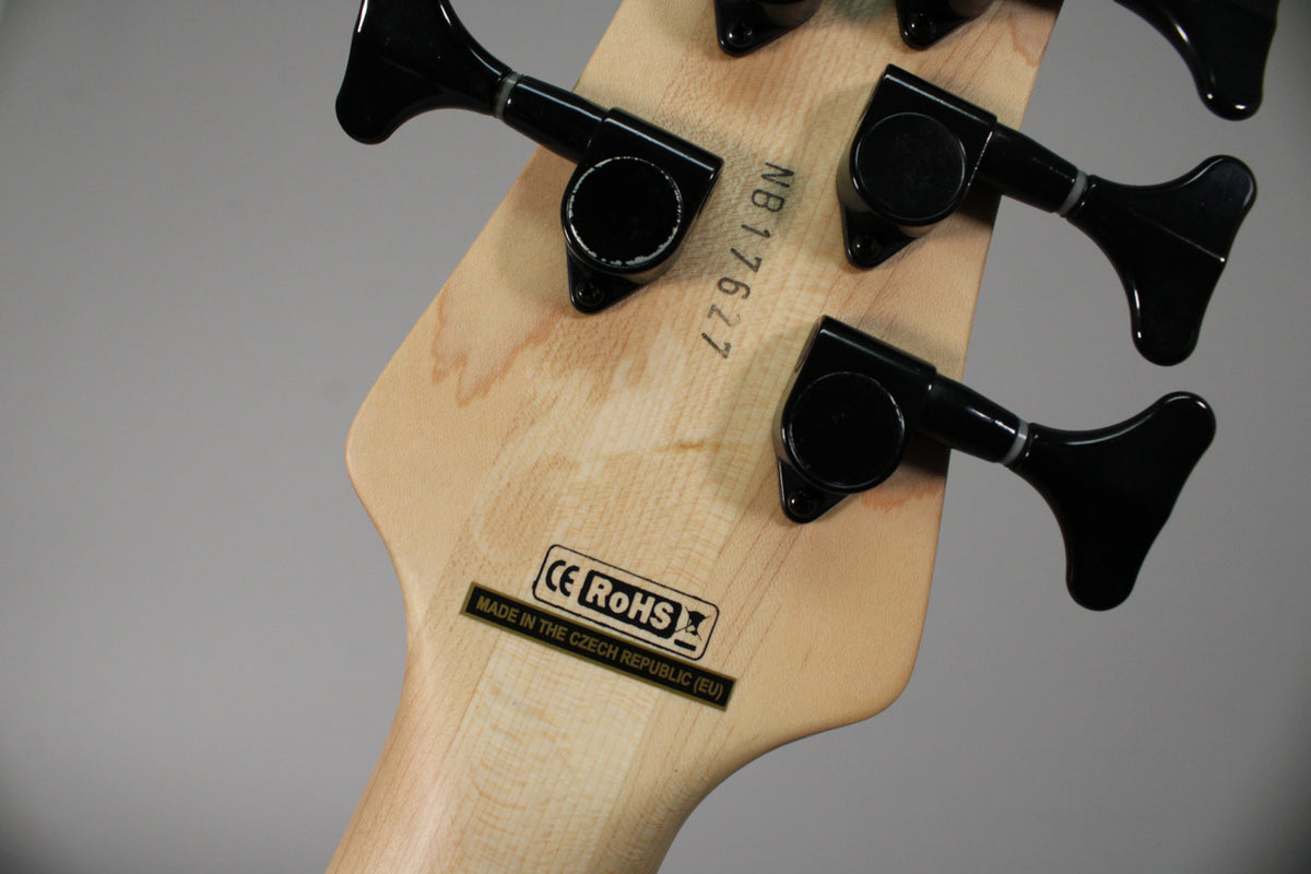 The back of a light wood headstock with five black tuning machines, a serial number, and "Made in the Czech Republic (EU)" label.