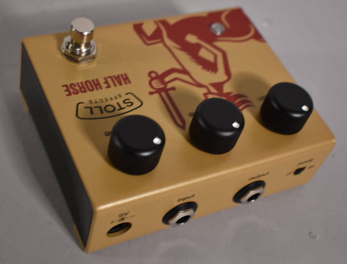 Gold pedal with a red knight graphic, three black knobs, a silver footswitch, and input/output jacks on the front face.
