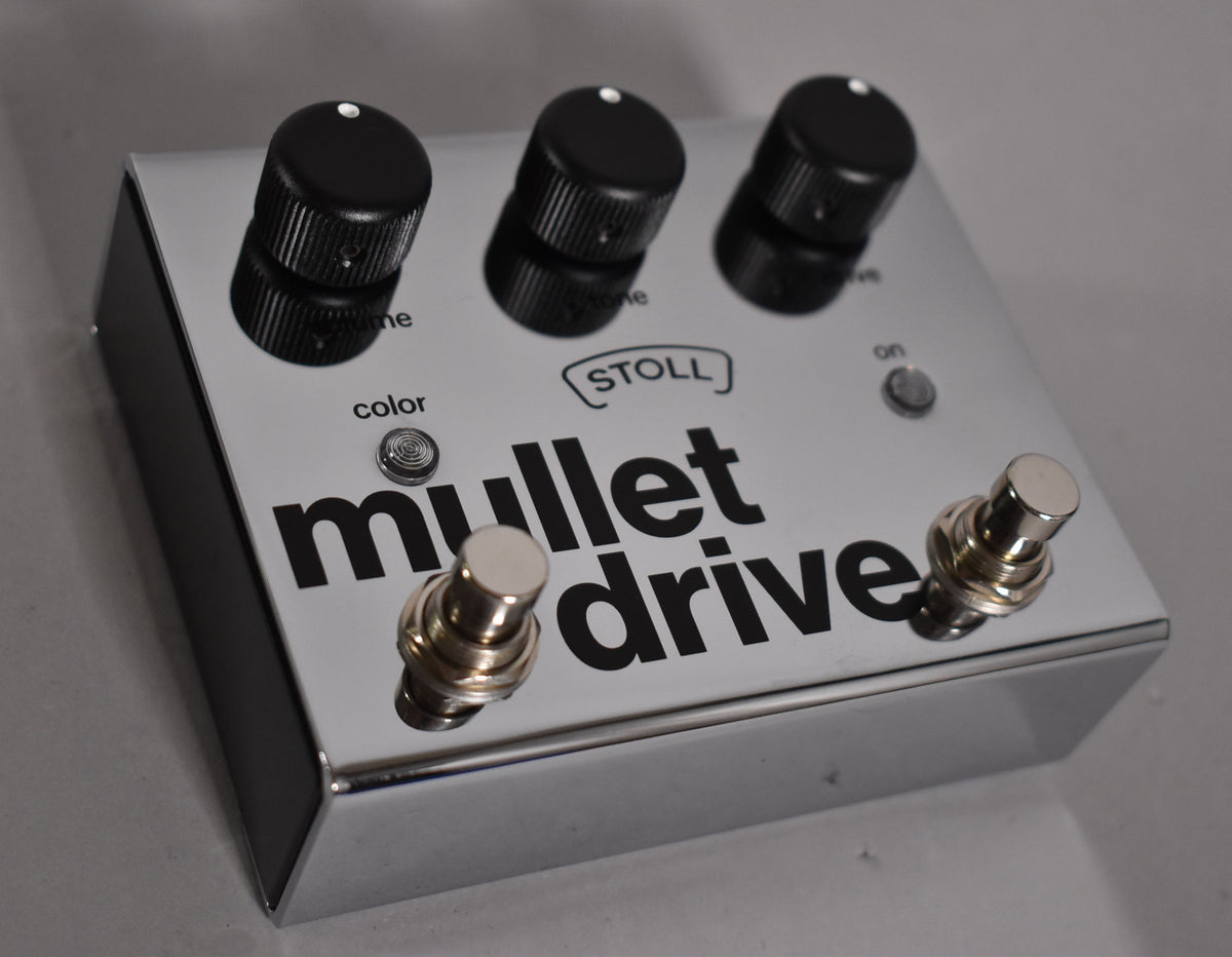 A chrome-finished guitar pedal, viewed from above and angled right, with three black knobs, a small silver button, and two footswitches.