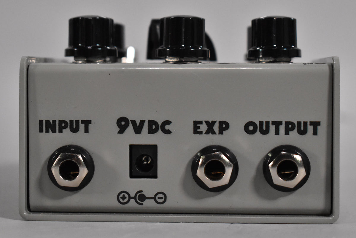 Rear view of a light grey pedal, showing input, 9VDC power, expression pedal, and output jacks.