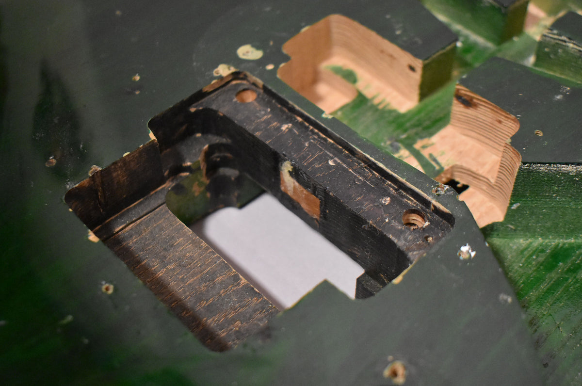 Close-up of the translucent green S-style guitar body, showing the Floyd Rose tremolo route and pickup cavities with exposed wood.
