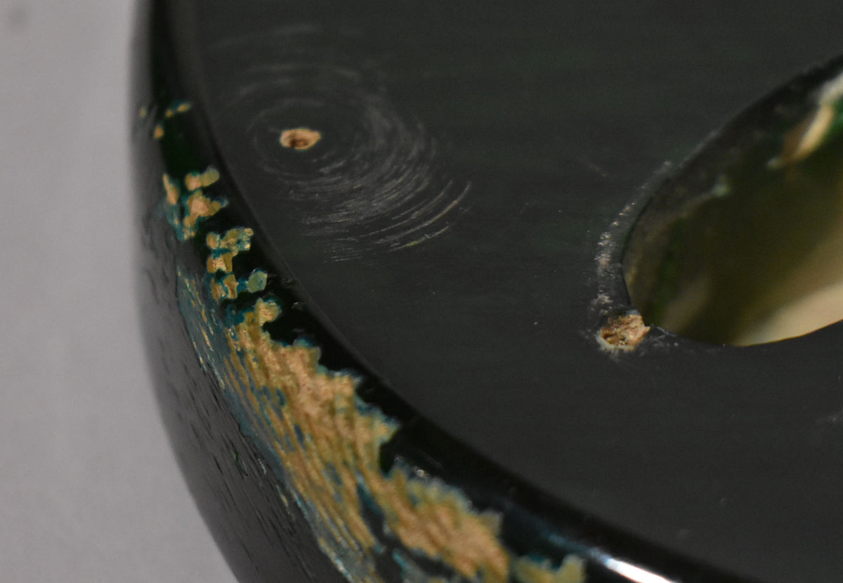 Close-up of the translucent green body, showing heavy finish wear on the edge and swirl marks on the top surface.