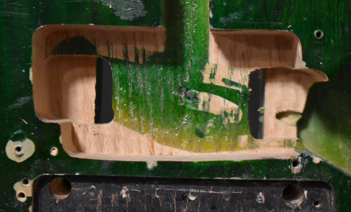 Close-up of the translucent green body, showing the HSH pickup cavities and the Floyd Rose tremolo route, with visible wood grain.