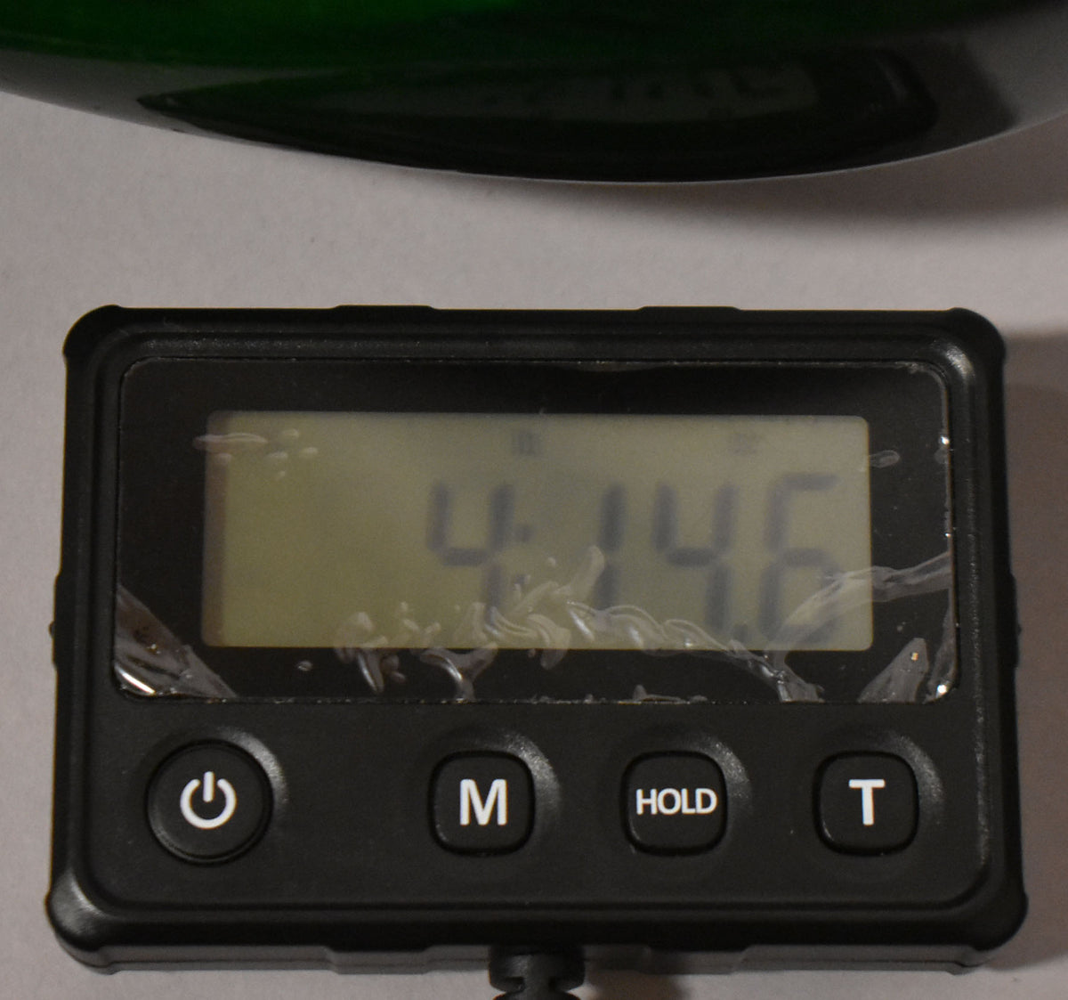 The translucent green S-style guitar body is shown from above, resting on a digital scale displaying "4.146".