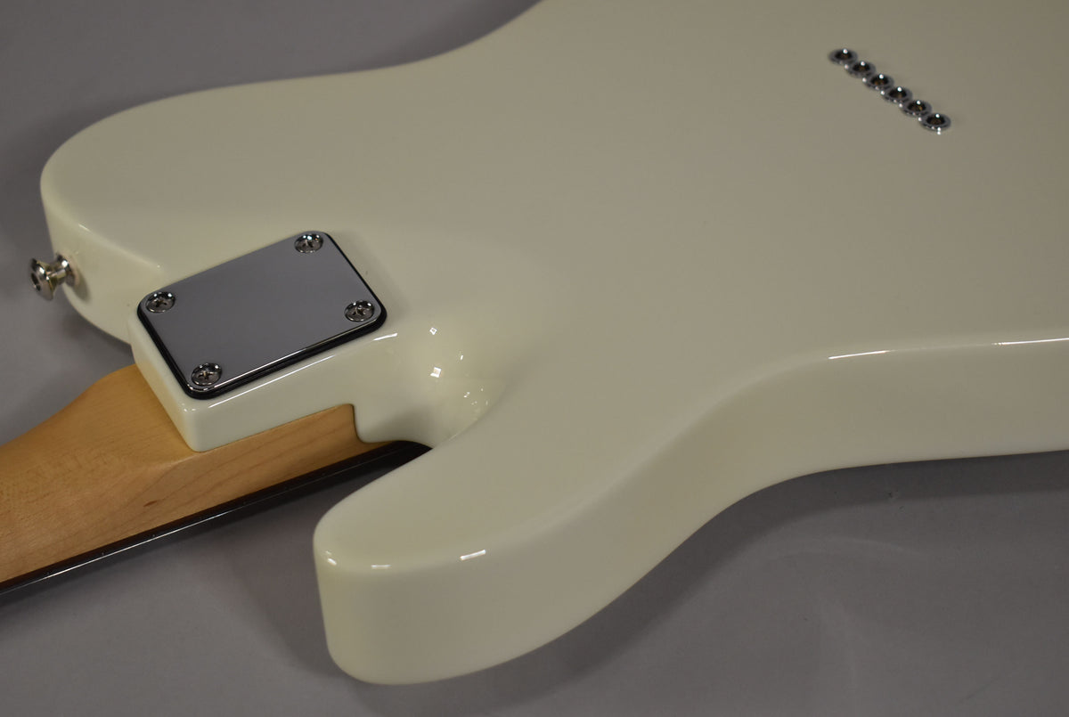 The back of an Olympic White guitar body, showing the neck plate, strap button, and six string-through-body ferrules.